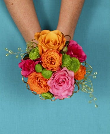 Handheld bouquet of orange, pink, and green flowers