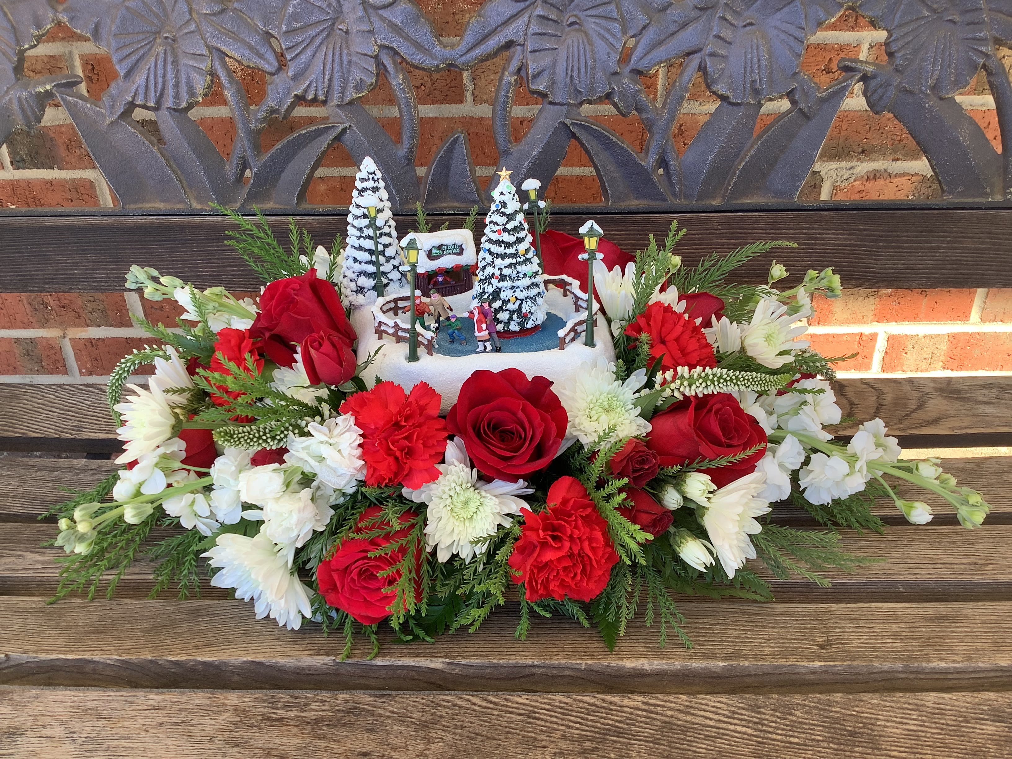 Red and white floral arrangement with a winter village centerpiece