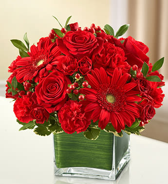 Healing Tears - All Red - Product ID: 95396  The symbol of courage and strength, an all-red bouquet conveys your sympathies with striking beauty. Our florists fill a stylish cube vase with roses, spray roses, Gerberas, carnations and more to send a fitting tribute during times of sorrow. Elegant arrangement of red roses, spray roses, Gerbera daisies, carnations, mini carnations and hypericum, accented with variegated pittosporum and myrtle Artistically designed by our florists in a classic clear glass cube vase lined with a Ti leaf ribbon; vase measures 5"H x 5"D Appropriate for the service or for sending to the home or office of friends and family members Large arrangement measures approximately 11"H x 11"L Medium arrangement measures approximately 10"H x 10"L Small arrangement measures approximately 9"H x 9"L Our florists hand-design each arrangement, so colors, varieties, and container may vary due to local availability