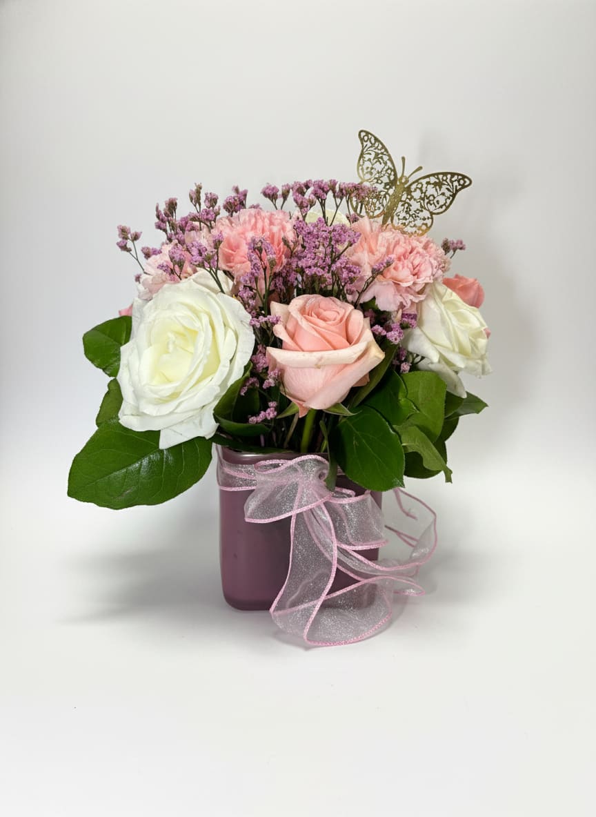 Pink Lady - Soft, sweet, and effortlessly elegant, Pink Lady is a charming arrangement designed to delight. Featuring a beautiful blend of ivory roses, blush pink blooms, and delicate accents of textured filler, this piece brings together romance and grace in the most graceful way.  Arranged in a modern blush-toned vessel and finished with a soft ribbon detail, Pink Lady is perfect for celebrating life’s special moments—from birthdays and thank-yous to “just because.”  A timeless beauty with a feminine touch—made to brighten any space and every mood.