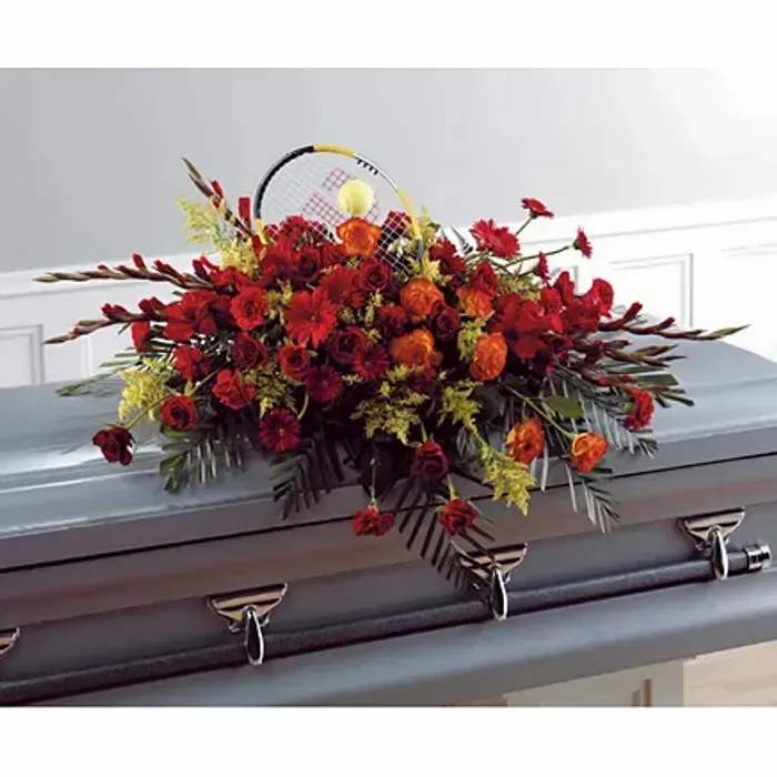 Fall Casket Spray – Seasonal Funeral Flower Arrangement - Honor a loved one with our Fall Casket Spray, a beautiful funeral flower arrangement featuring rich, seasonal autumn colors. Handcrafted by our expert florists, this arrangement includes fresh blooms in warm oranges, deep reds, golden yellows, and earthy tones, creating a meaningful and elegant tribute.  For a personal touch, an optional tennis racket can be included in the arrangement, perfect for honoring a loved one’s hobbies or passions. We also offer customizations to make the spray uniquely meaningful, from flower types to color palettes.  Ideal for casket displays, graveside ceremonies, and memorial services, this spray conveys love, respect, and heartfelt remembrance while reflecting the beauty of the fall season.  Ordering Information: Each arrangement is handcrafted with fresh, seasonal flowers. Please place orders in advance to ensure availability.  Note: Flower varieties may vary slightly based on seasonal availability.  Product ID: 1535 