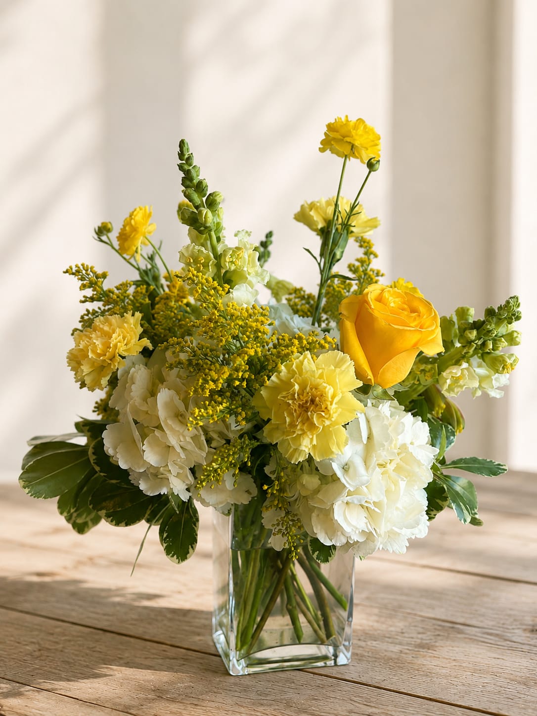 Yellow and white floral arrangement in a clear glass vase