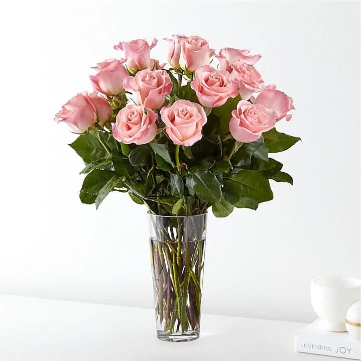 Pink roses arranged in a clear glass vase
