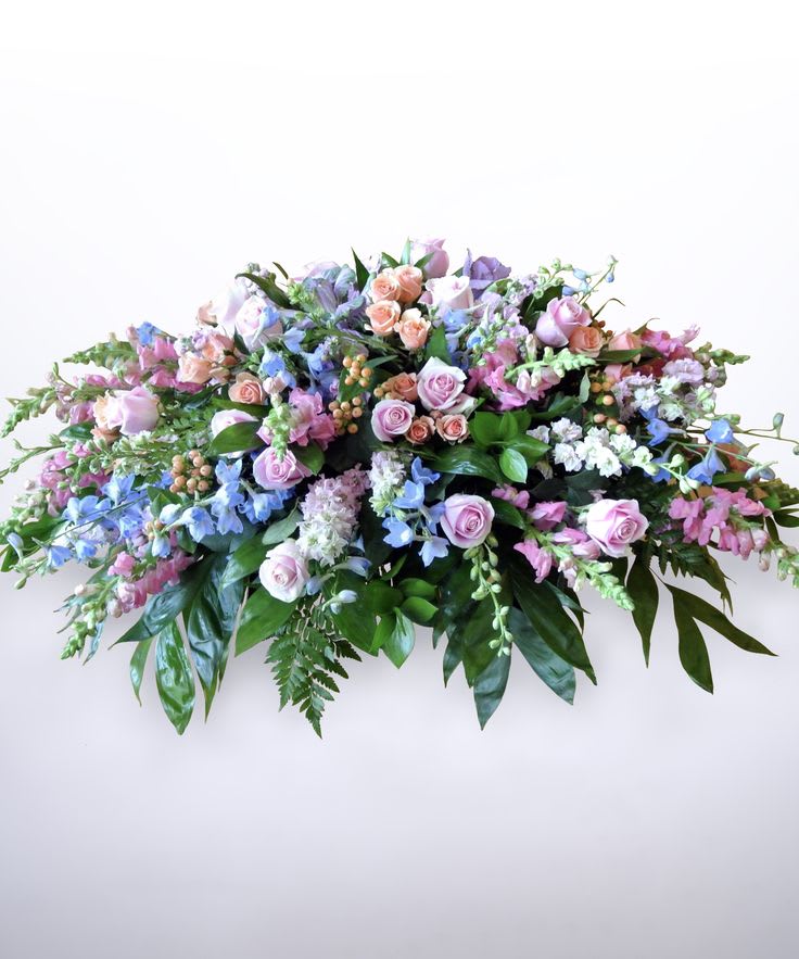 Large pastel floral spray with pink and lavender roses and blue flowers