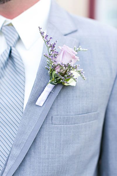 Boutonniere with a pale pink rose on a gray suit lapel