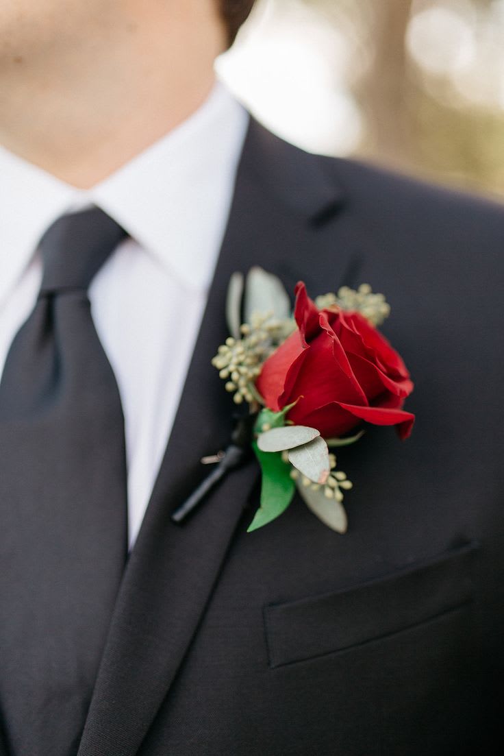Red rose boutonniere on a black suit lapel