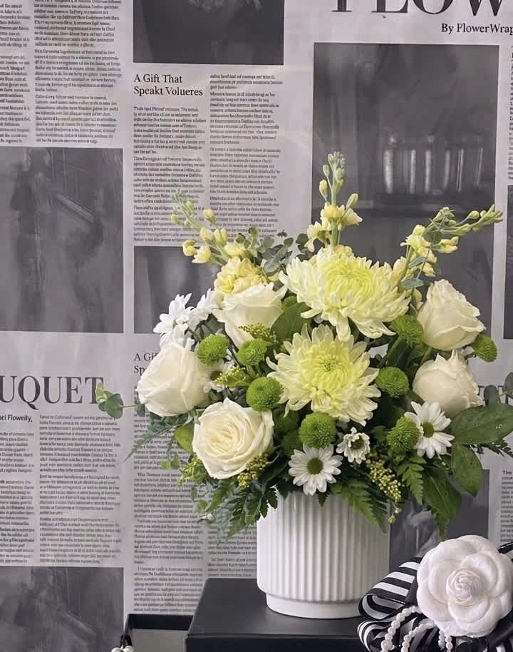 White roses and pale yellow chrysanthemums in a white vase