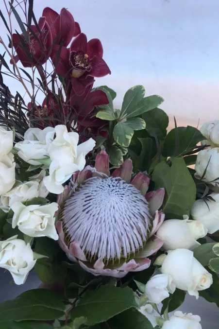 Bouquet with white roses and a large protea bloom