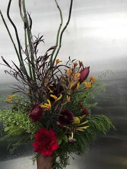Tall tropical bouquet with red and burgundy flowers