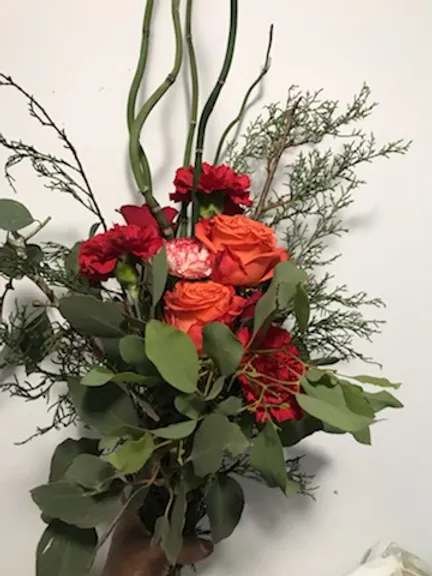 Bouquet of orange and red roses with greenery