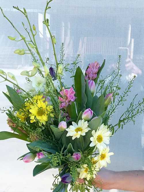 Mixed bouquet with yellow daisies, pink tulips, and white blooms