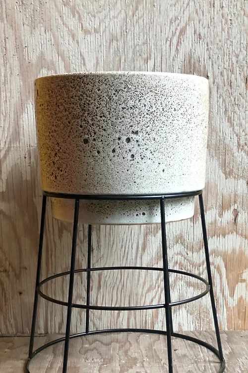Speckled ceramic planter on a black metal stand