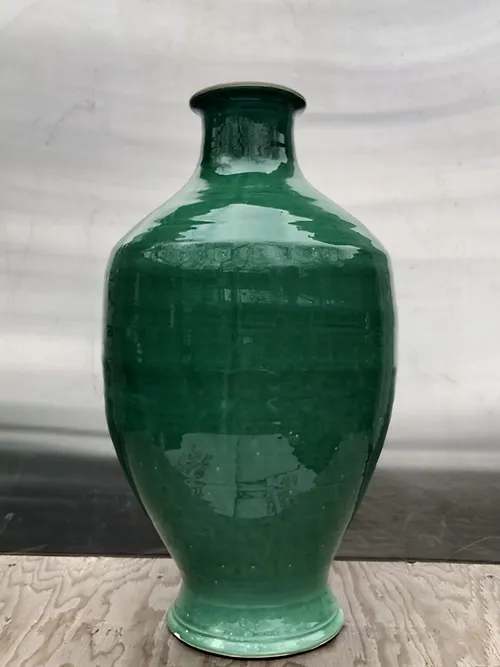 Green ceramic vase with a narrow neck and rounded body