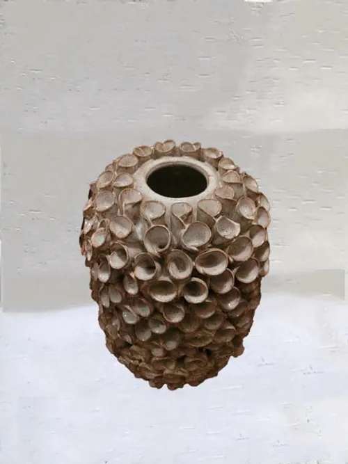 A textured brown ceramic vase with a round opening