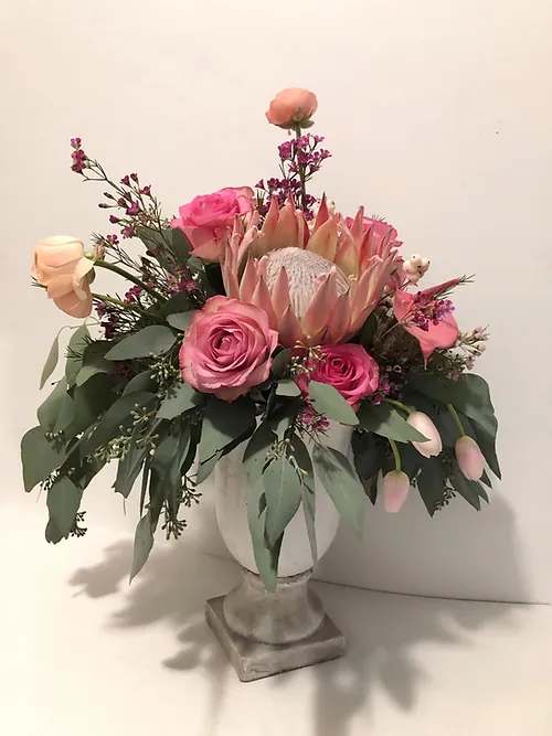 Pink and peach floral arrangement in a white vase