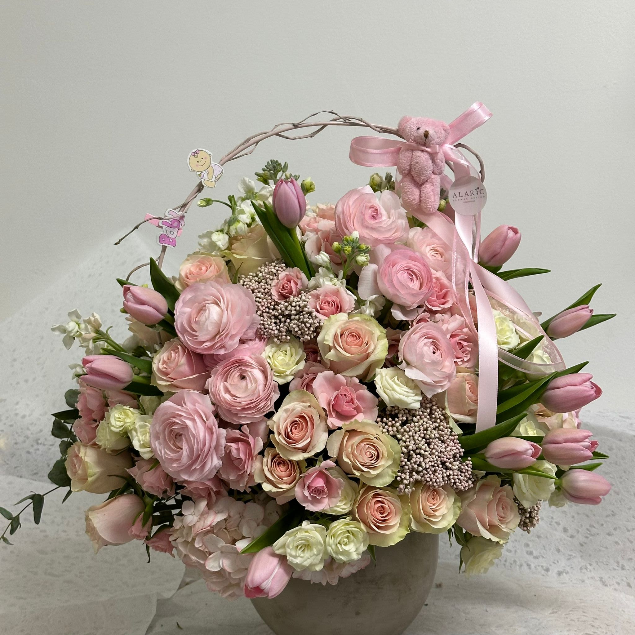 Madison - Celebrate the arrival of a baby girl with this stunning arrangement of tulips, roses, hydrangeas, and ranunculus! This beautiful bouquet is the perfect way to congratulate the new mom and welcome her little one with joy and elegance.  Note: Please note that the pot and stems may vary according to availability and season.