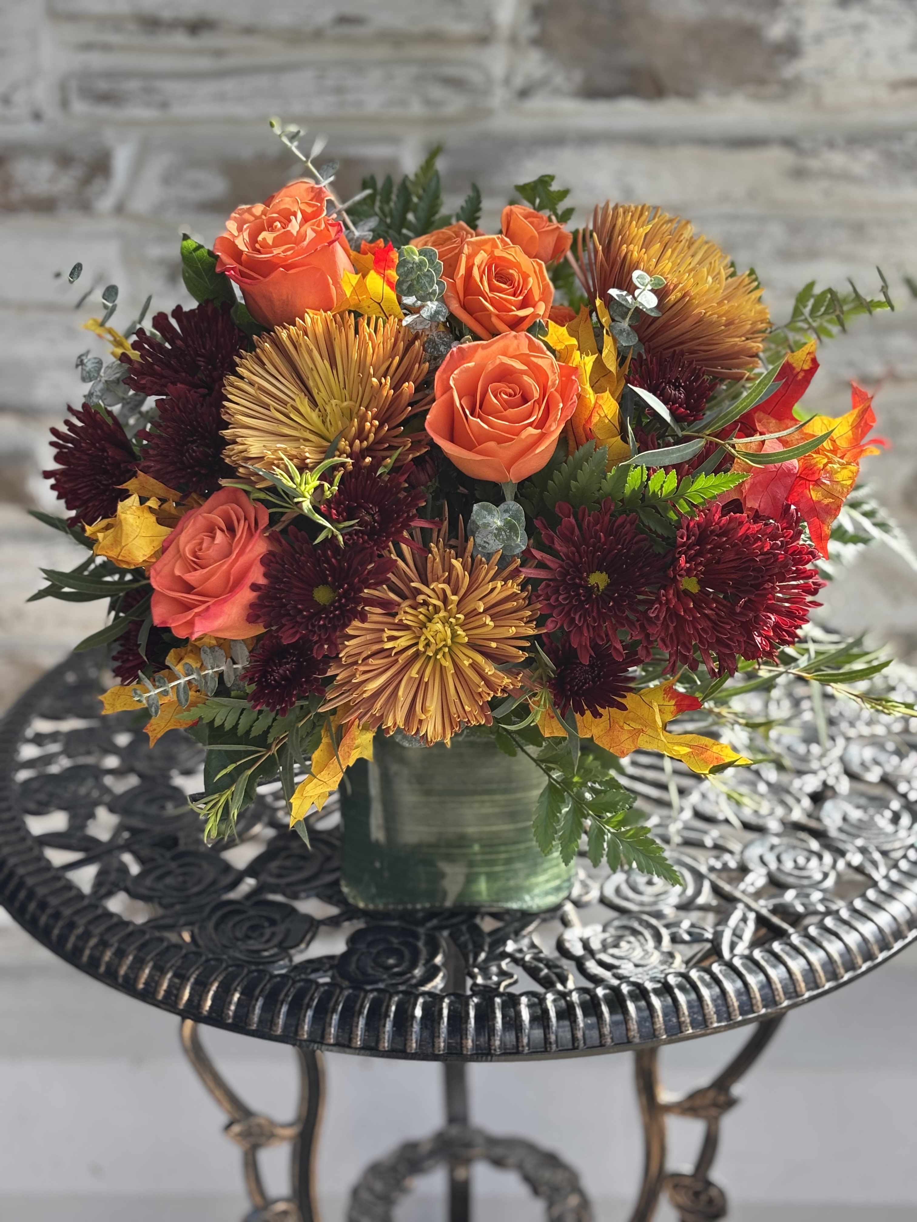 Fall'n For You - Fall in love with this sweet fall arrangement. Roses, mums and mixed foliage make this a perfect addition to your fall decor. One sided arrangement.