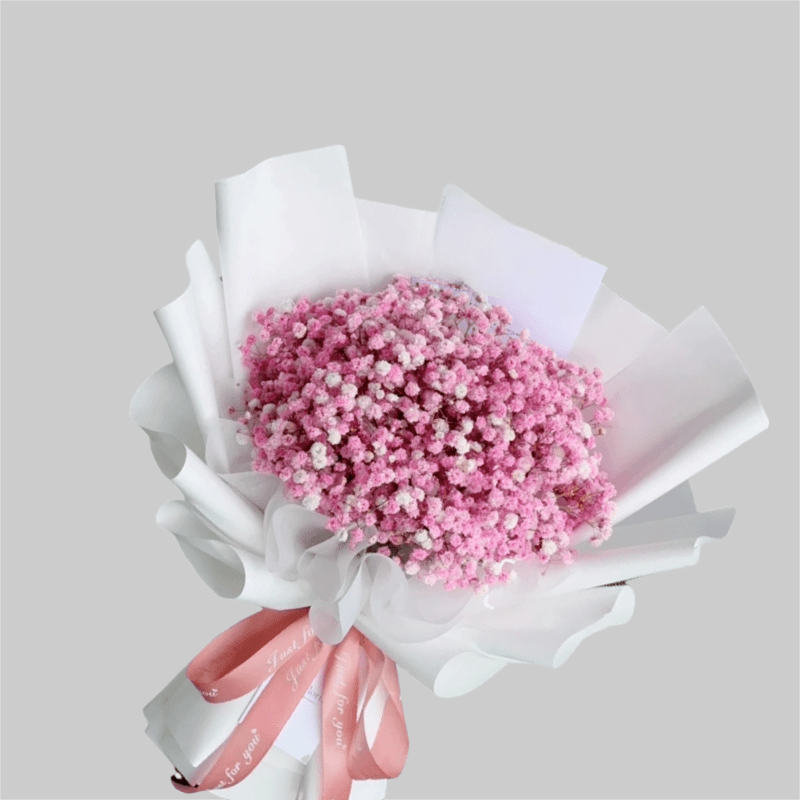 Pink baby's breath bouquet wrapped in white paper with a pink ribbon