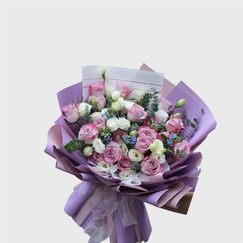 Bouquet of pink and white roses wrapped in lavender paper