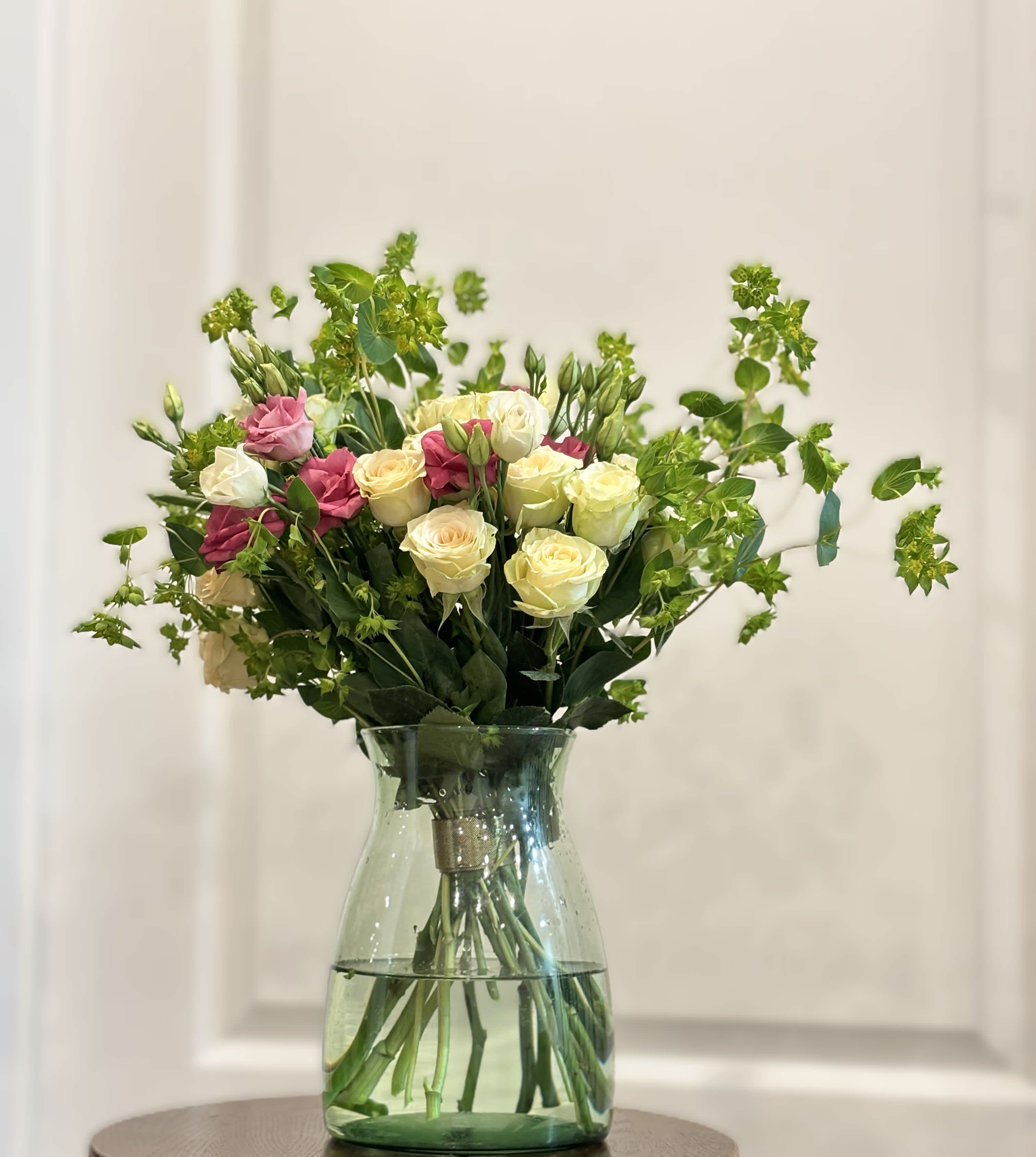 Bouquet of pink and cream roses in a clear glass vase