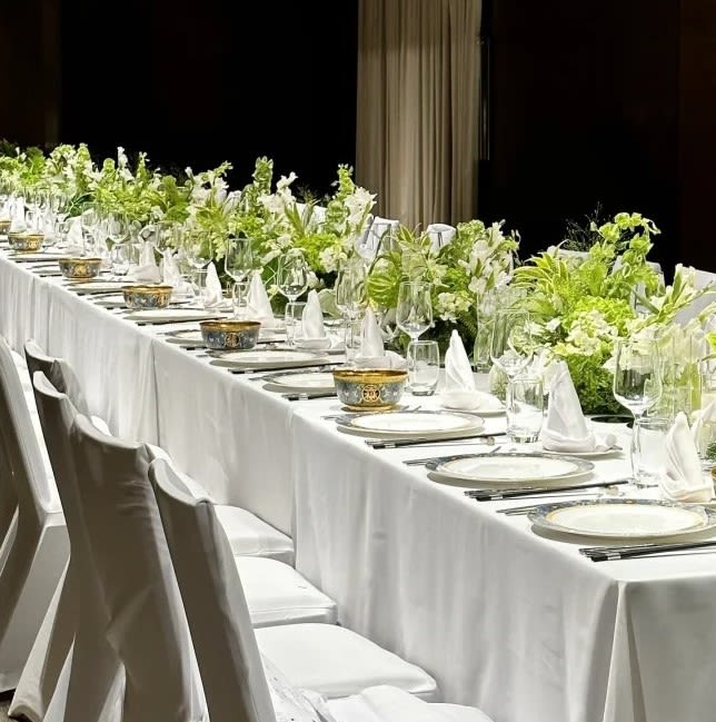 Long banquet table with white floral centerpieces and place settings
