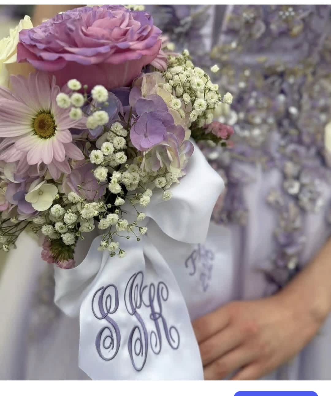 Pastel bouquet with a pink rose, daisy, and baby’s breath tied with a white ribbon
