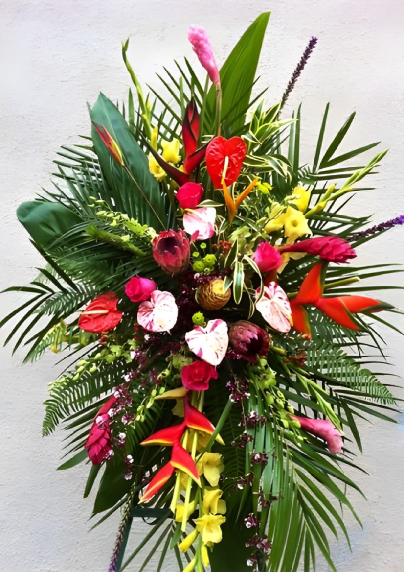 Tall tropical flower arrangement with red, pink, and yellow blooms