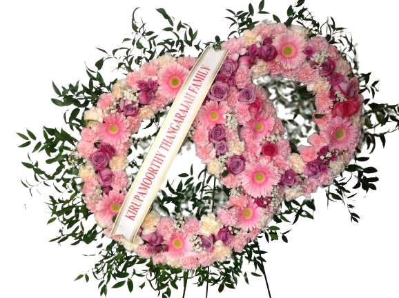 Pink floral funeral wreath with a condolence ribbon