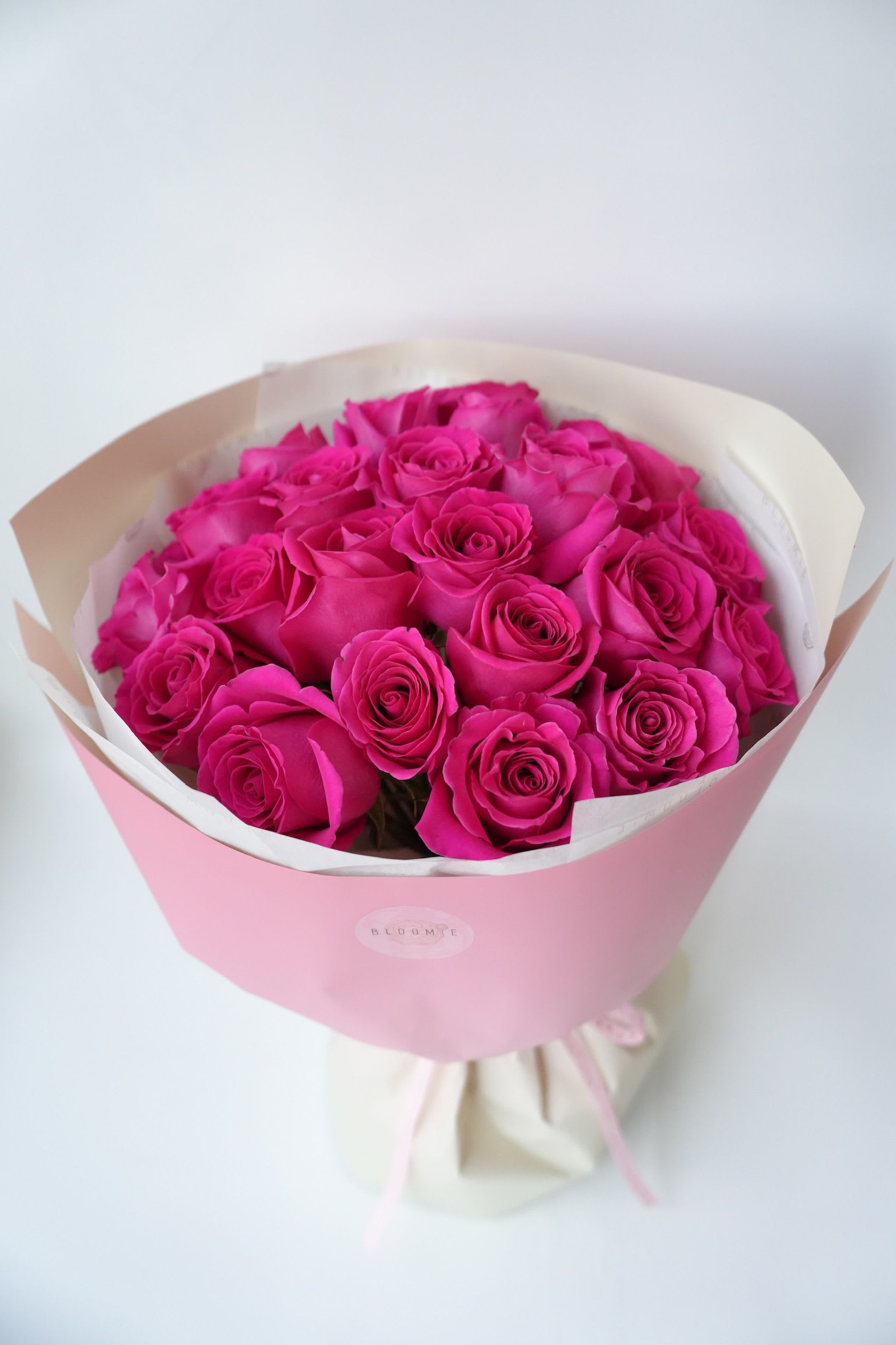 Bouquet of bright pink roses wrapped in pink paper
