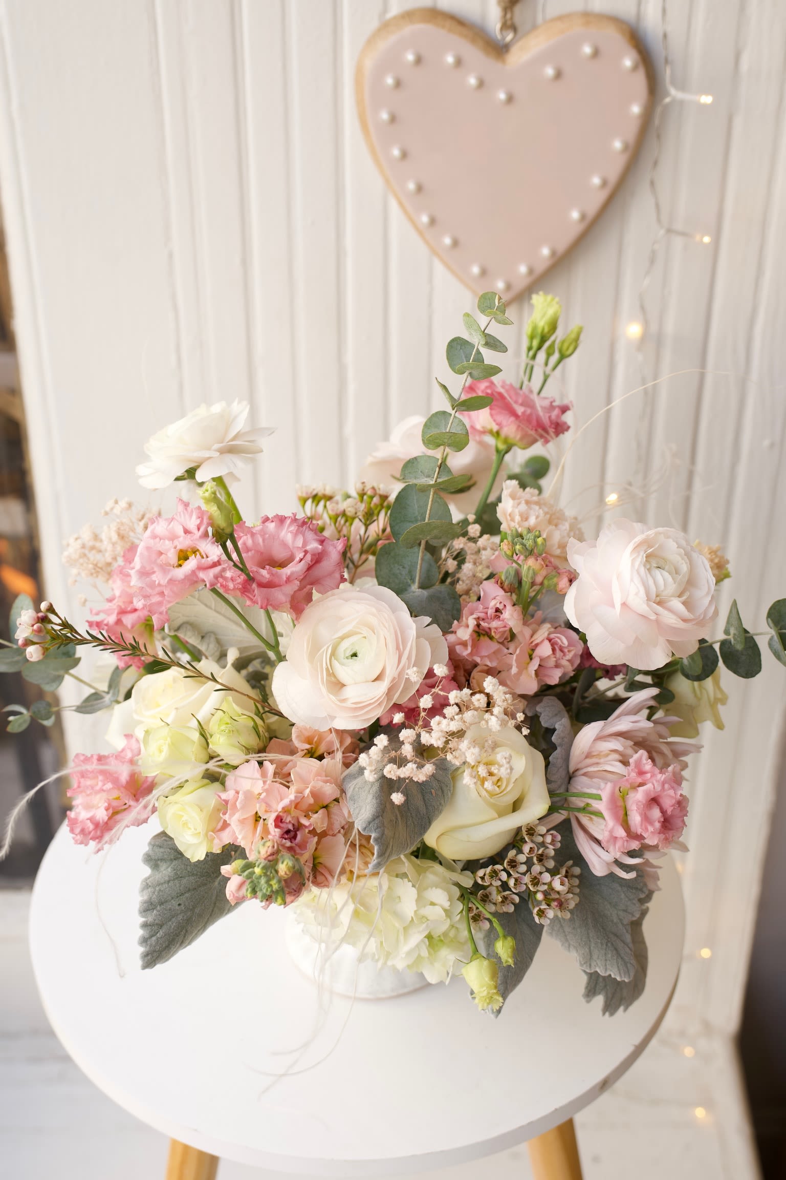 Pastel bouquet of pink and white flowers in a white container