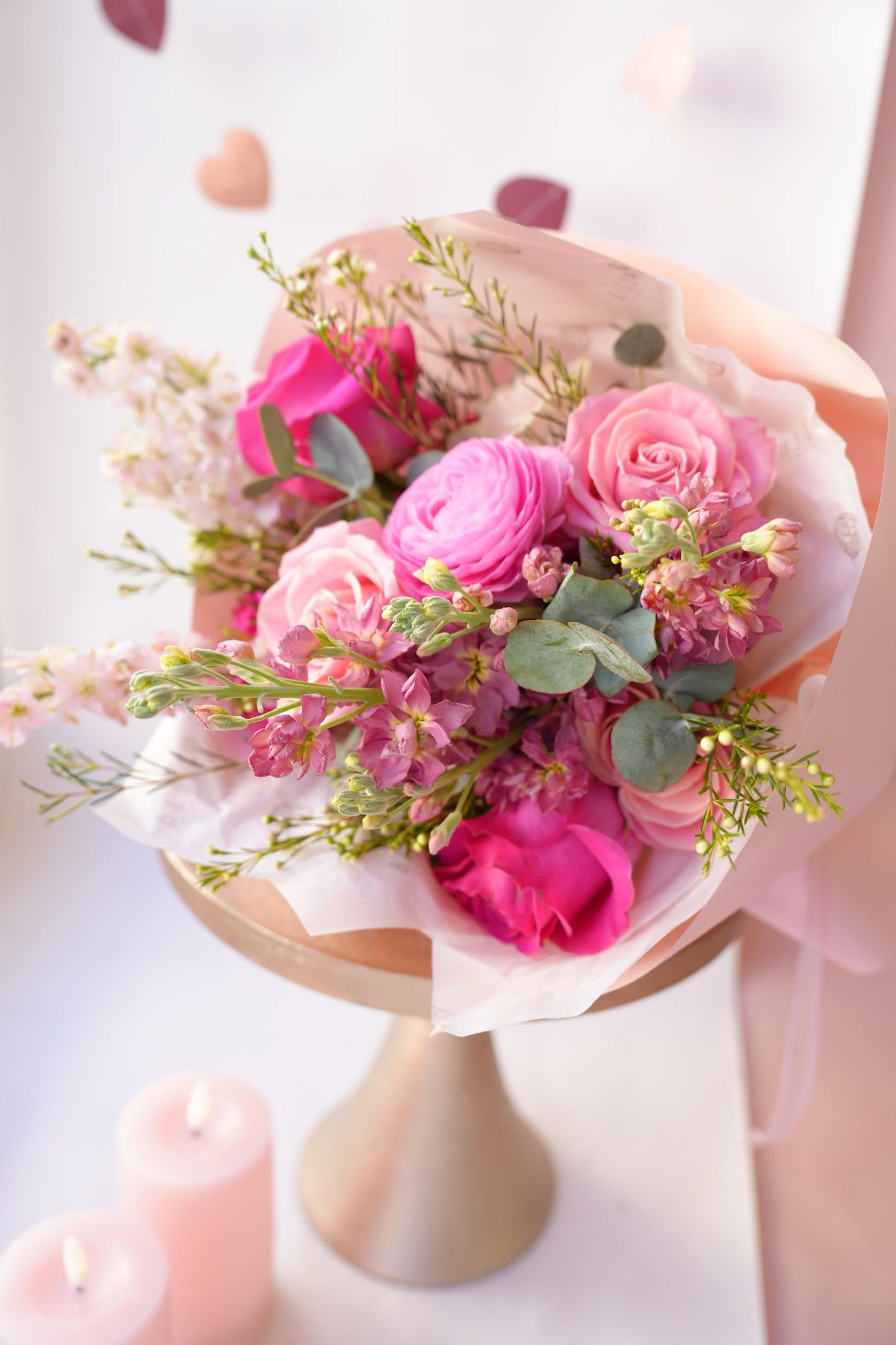 Pink rose and ranunculus bouquet wrapped in pale paper