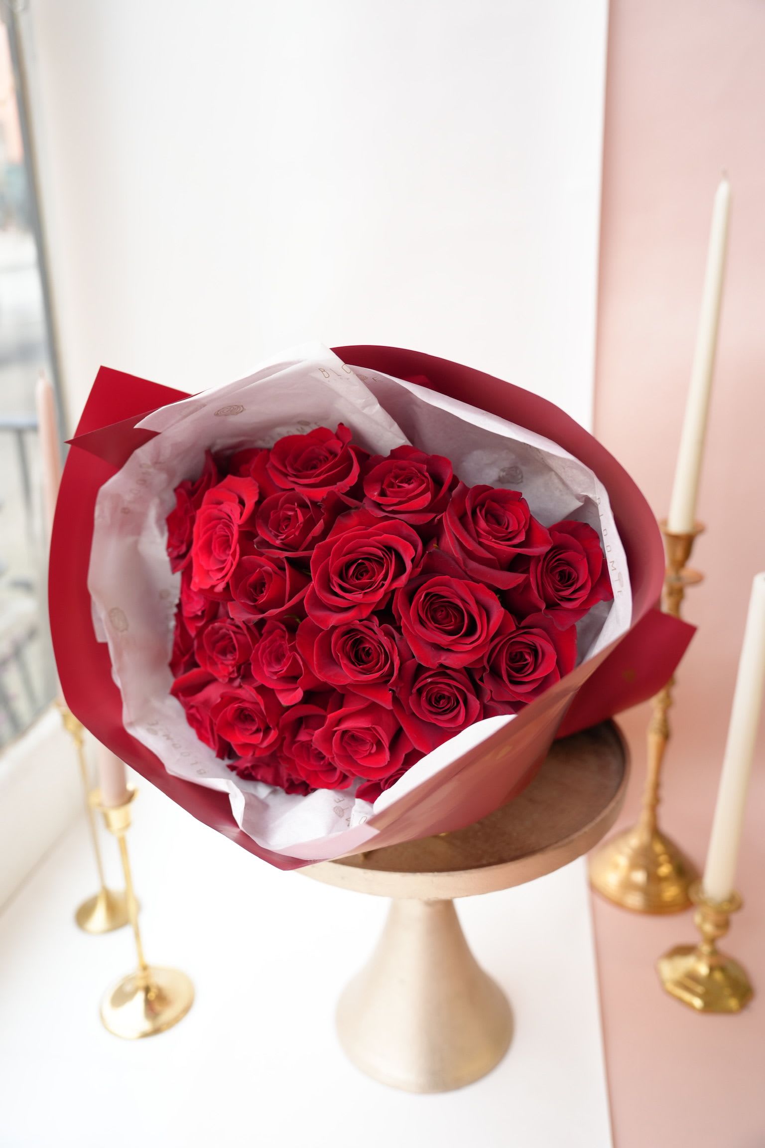 Bouquet of red roses wrapped in red and white paper
