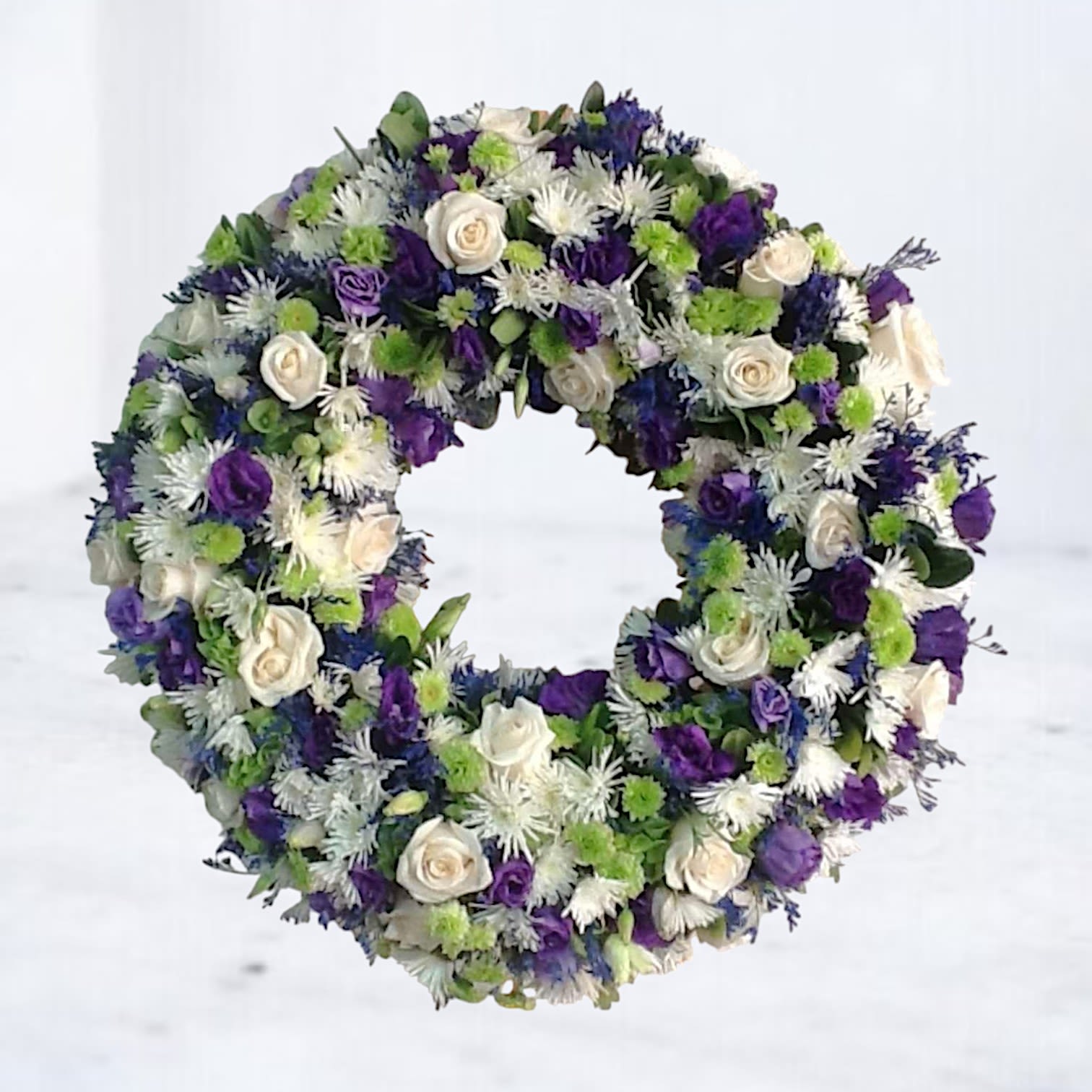 Circular wreath of white, purple, and green flowers