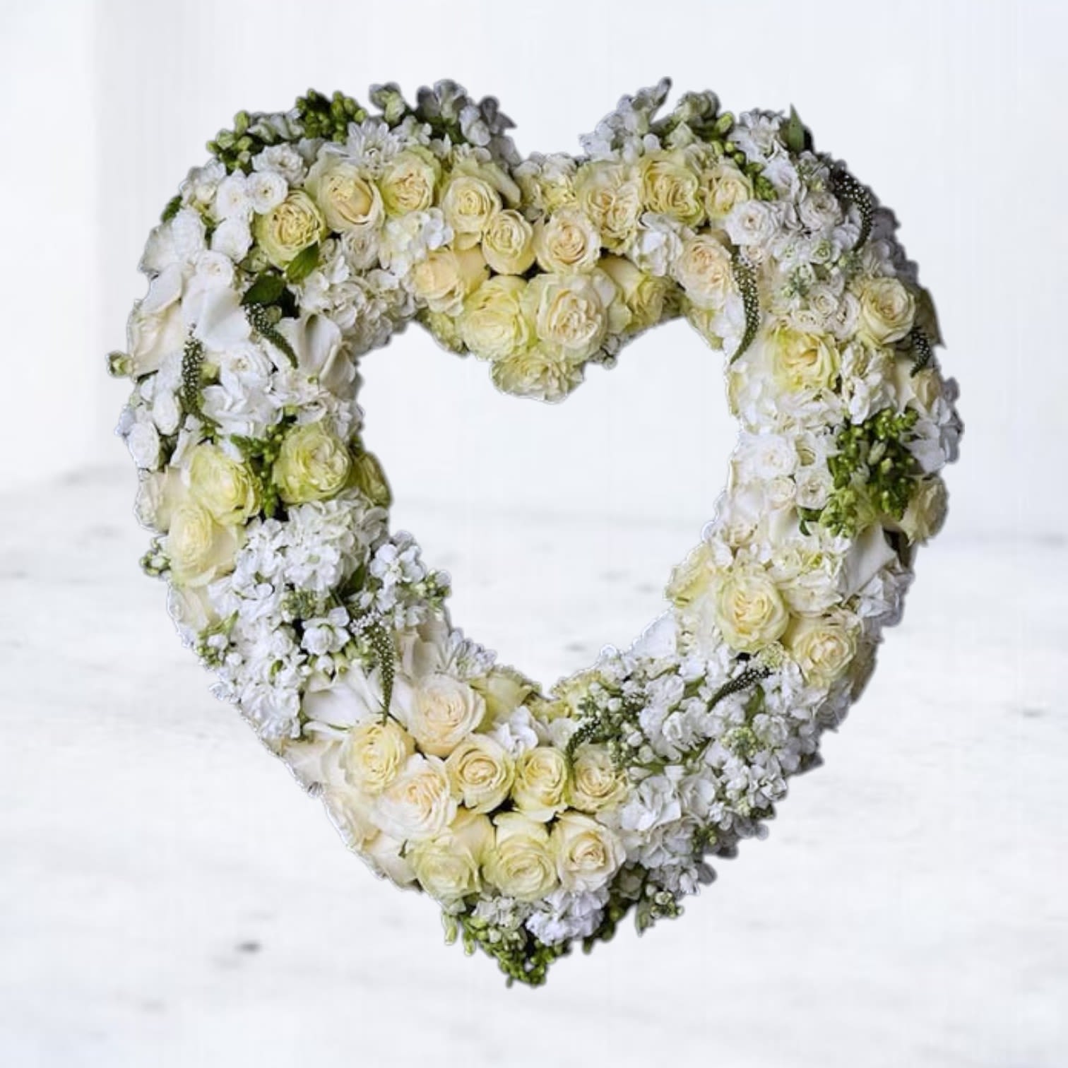 Heart-shaped floral wreath of white and pale yellow roses