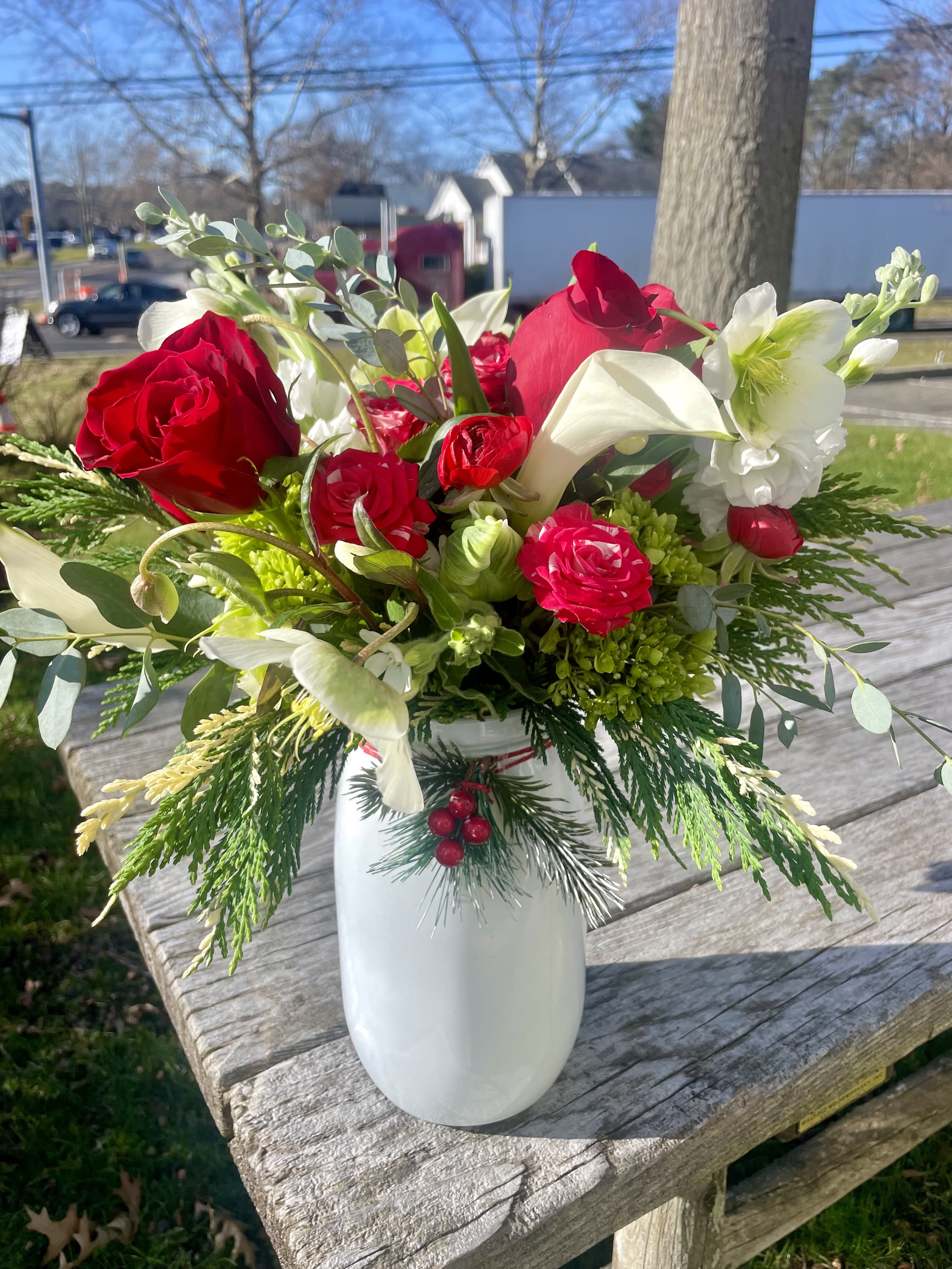 Red roses and white calla lilies in a white vase
