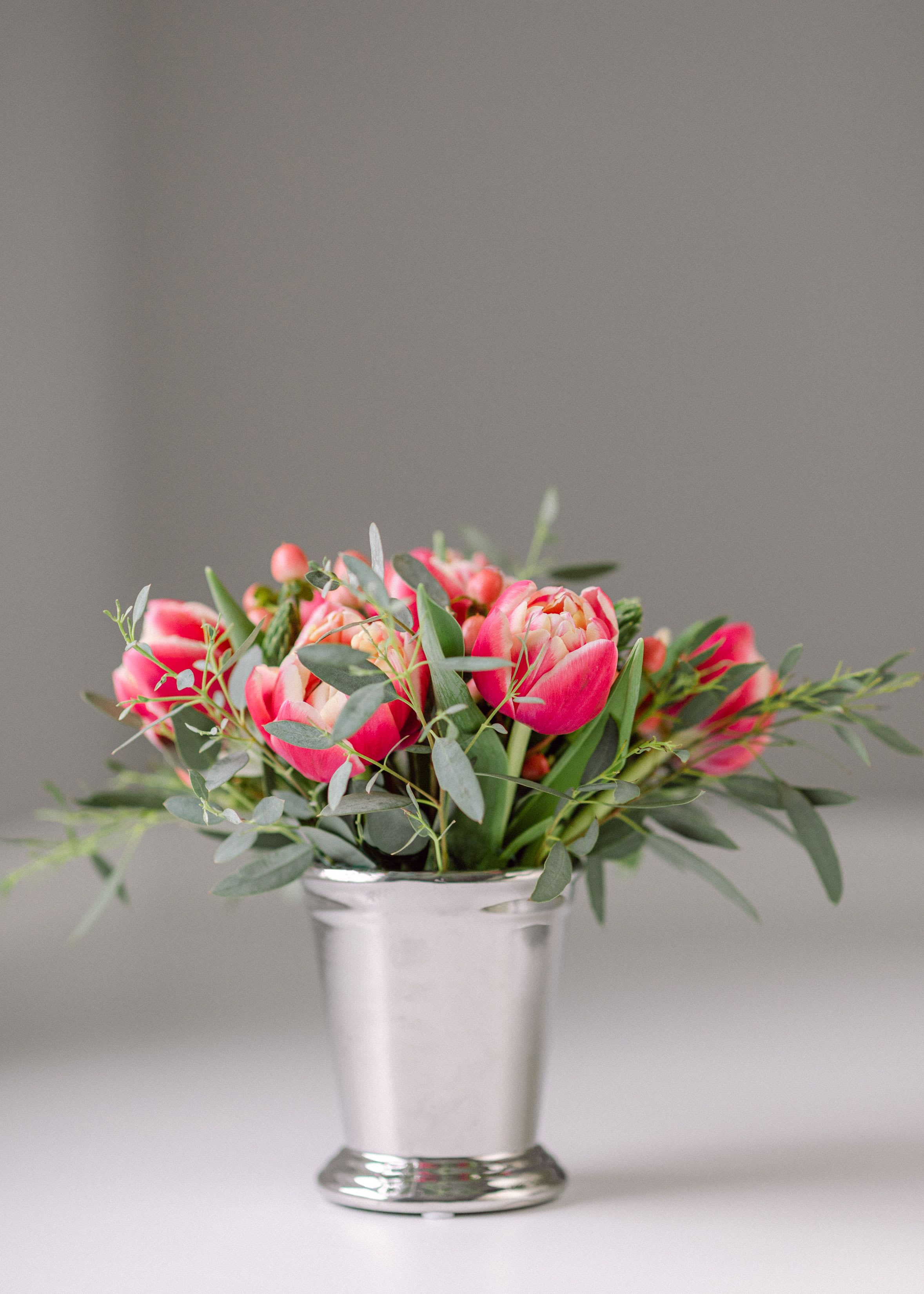 Tulip in a Julep!  - We love this so much for so many reasons but it is a perfect pick me up, hello, friend fave and all around people pleaser. We use fresh tulips, a touch of eucalyptus and a stainless julep cup that can be reused  (Mint Julep anyone?..)  We tend to use a premium tulip variety in the dark pink /red range or we can use white.. If you have a tulip color preference let us know and we will aim to accommodate if product is available.    Not eligible   Standard size= 1 Julep Deluxe Size= 2 Juleps Premium= 3 Juleps    