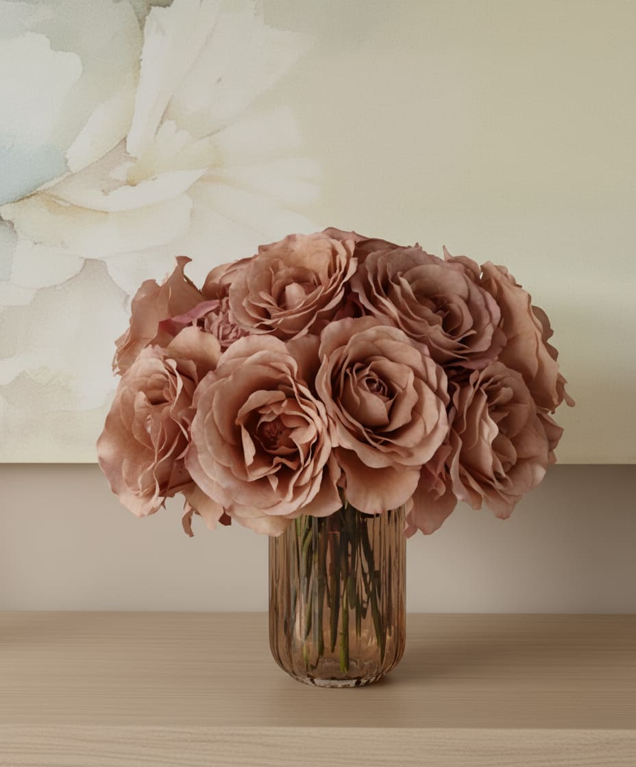 Blush roses arranged in a ribbed glass vase on a tabletop
