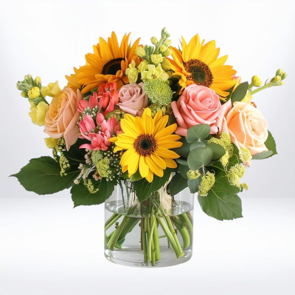 Sunbeam Bloom - Bright, bold, and full of cheer—Sunbeam Bloom is a radiant burst of joy for any occasion. Featuring vibrant sunflowers, citrus-toned roses, sunny snapdragons, and playful pink alstroemeria, this bouquet brings together everything you love about warmth, color, and celebration in one stunning glass vase arrangement.  Perfect for birthdays, get well wishes, or simply making someone’s day a little brighter, this design is available for same-day flower delivery in Galveston, League City, Friendswood, Dickinson, and surrounding Texas Gulf Coast communities. Send sunshine with Twigs and Blooms—where every bouquet is handcrafted with heart.  Substitution Disclaimer: In the event certain blooms are unavailable due to seasonality or freshness, we will substitute with flowers of equal or greater value in a similar color palette and style to ensure a beautiful and cohesive arrangement.