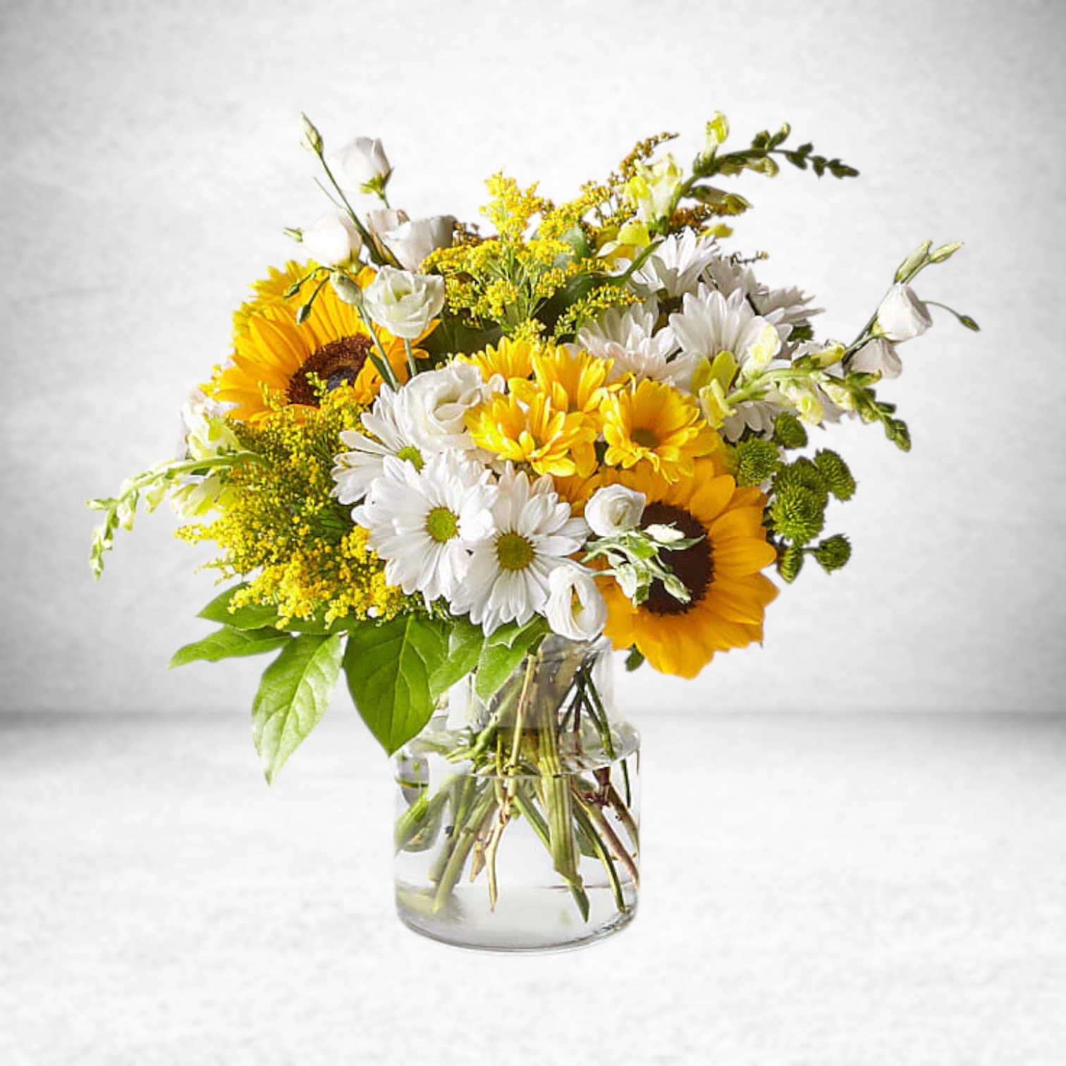 Hello Sunshine Bouquet - HELLO SUNSHINE BOUQUET Give a dose of sunshine in bloom. This stunning bouquet is teeming with rays of sunflowers, textured snapdragons and darling daisy poms to deliver the perfect pick–me–up for an occasion or as a treat to yourself.  Please Note: The bouquet pictured reflects our original design for this product. While we always try to follow the color palette, we may replace stems to deliver the freshest bouquet possible, and we may sometimes need to use a different vase