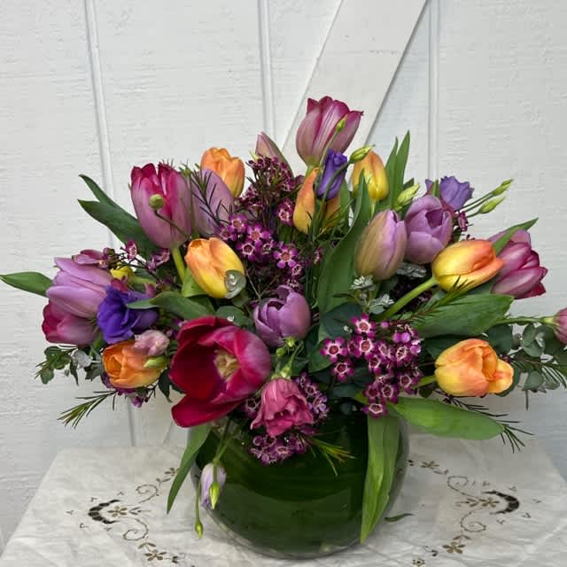 Colorful tulip bouquet in a green glass vase