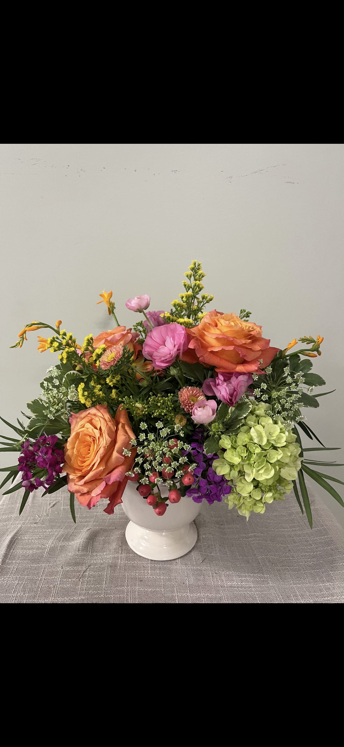 Colorful mixed bouquet in a white pedestal vase