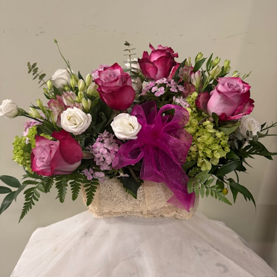 Pink and white rose bouquet in a textured box with a purple ribbon