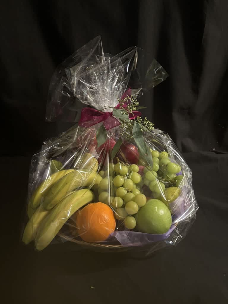 Wrapped fruit basket with bananas, grapes, and citrus