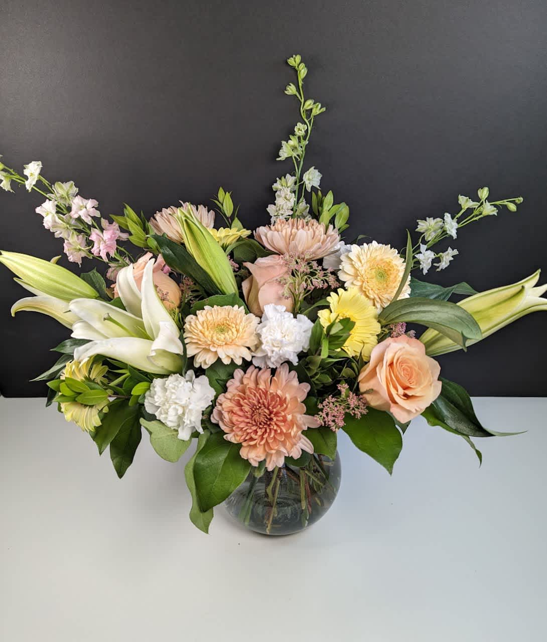 Mixed pastel bouquet in a round glass vase
