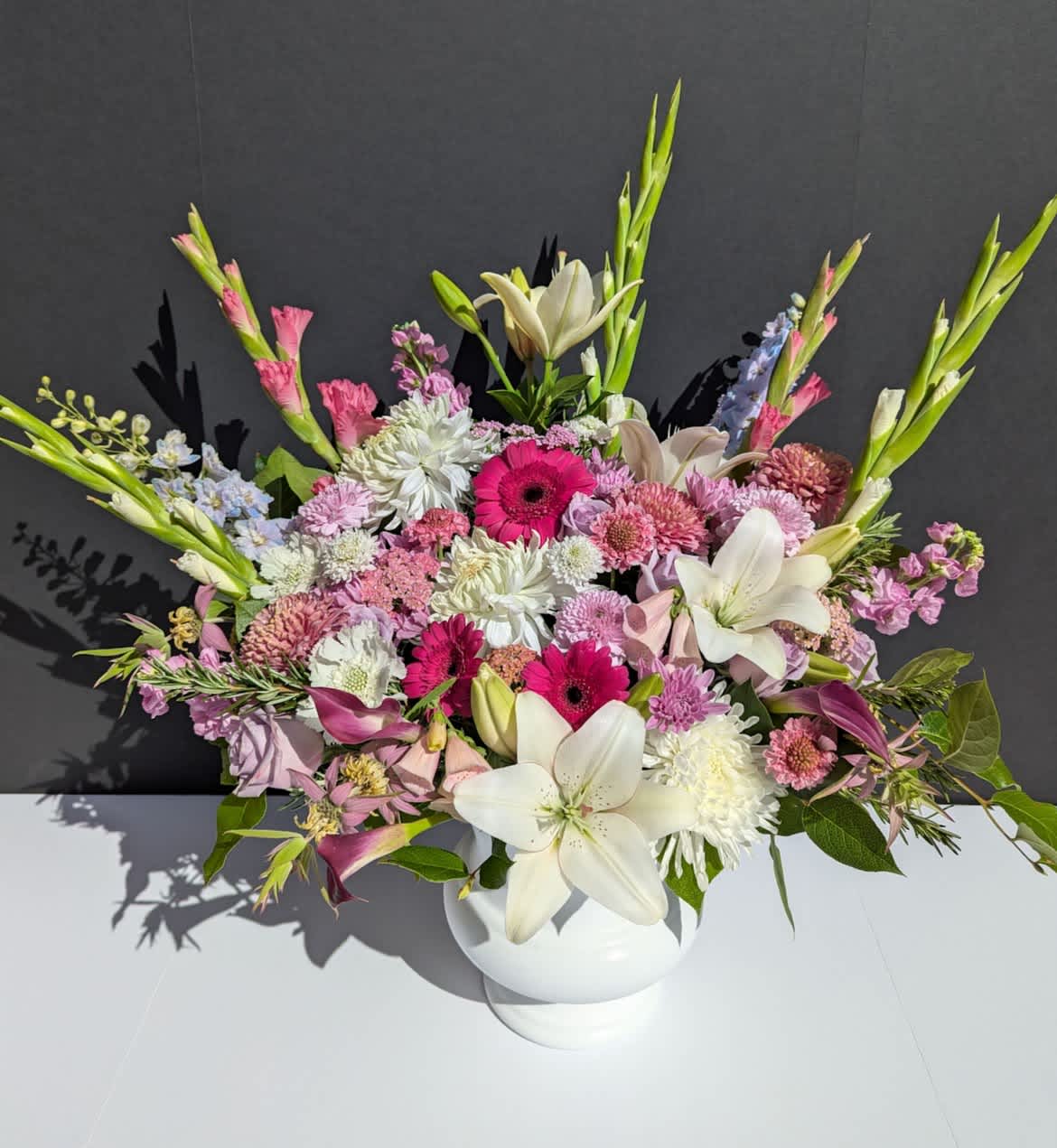 Mixed pink and white floral arrangement in a white vase