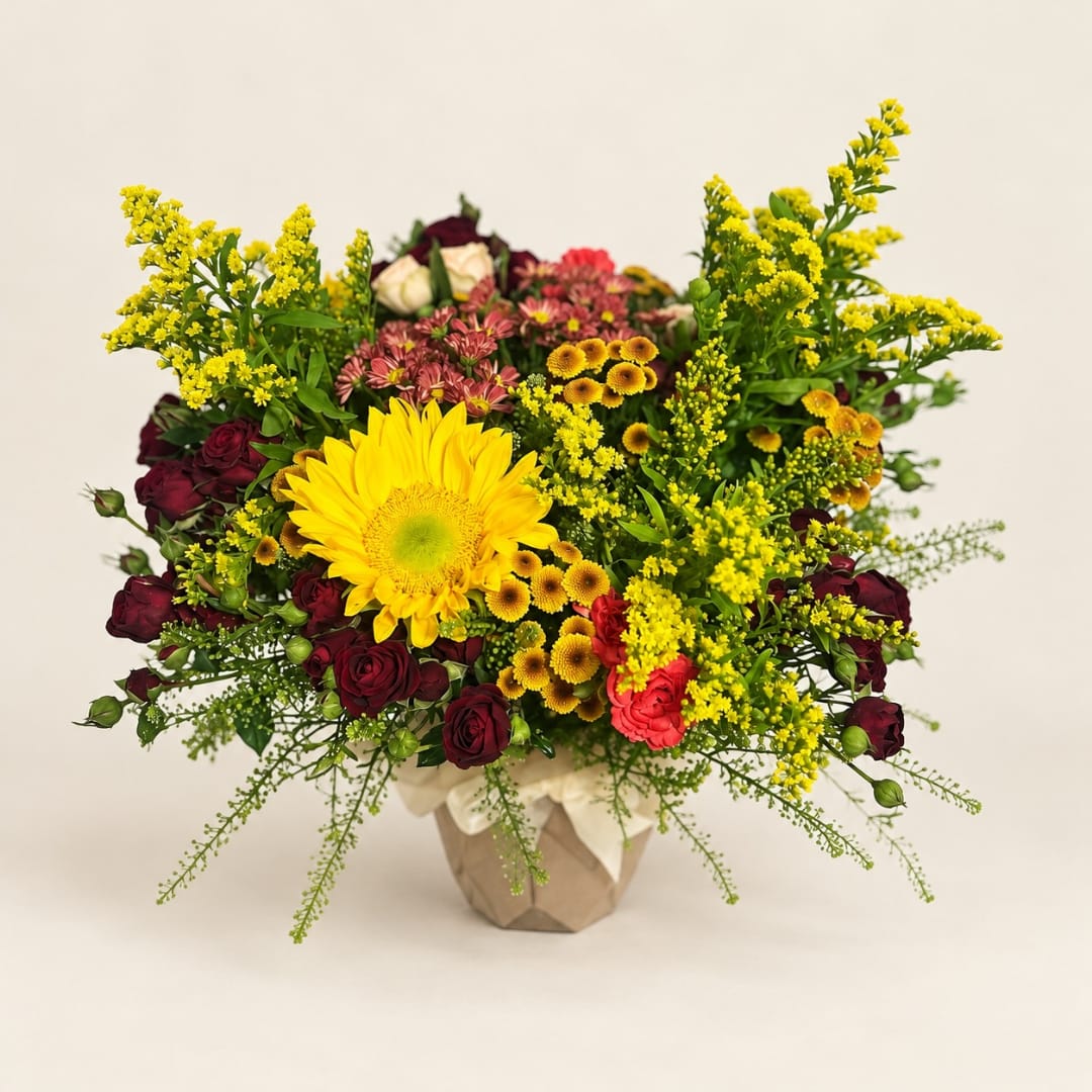 Mixed bouquet with a large yellow gerbera daisy and burgundy roses in a wrapped vase