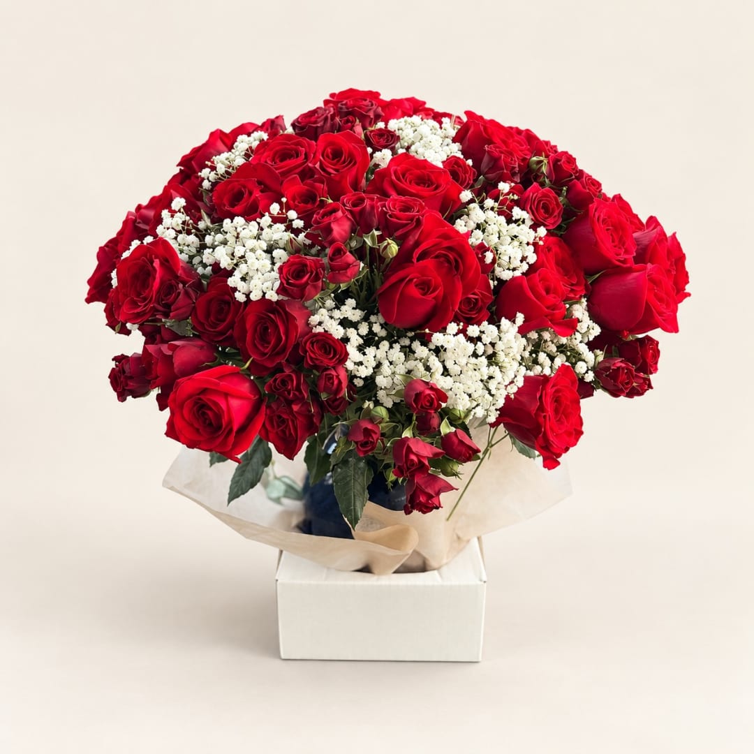 Bouquet of red roses with white filler flowers in a box