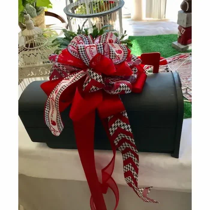 Black chest with a large red and patterned ribbon bow