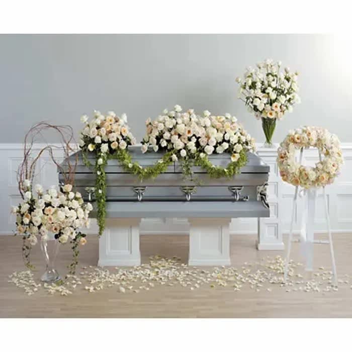 White floral funeral casket spray with matching wreath and standing arrangements