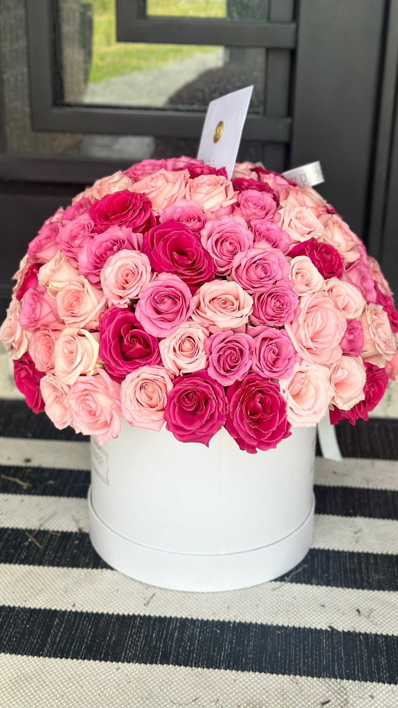 Round box arrangement of pink and blush roses